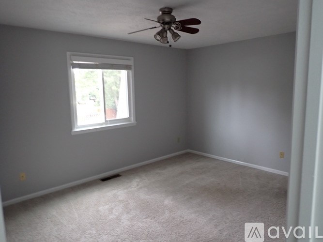 A room with a ceiling fan and a window.
