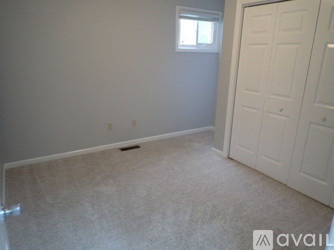 A room with a carpeted floor and a white door.