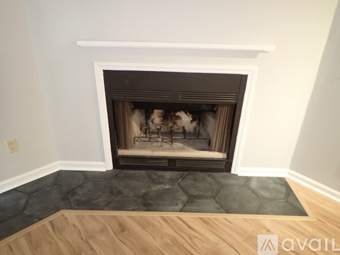 A fireplace with a white mantle and a black hearth.