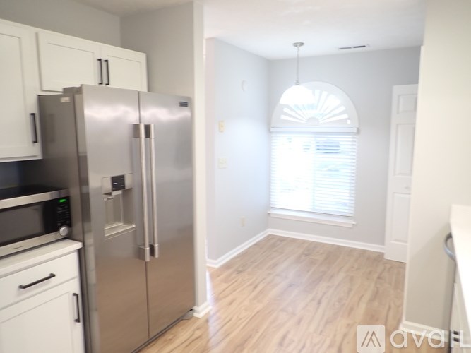 A kitchen with a refrigerator, microwave, and oven.