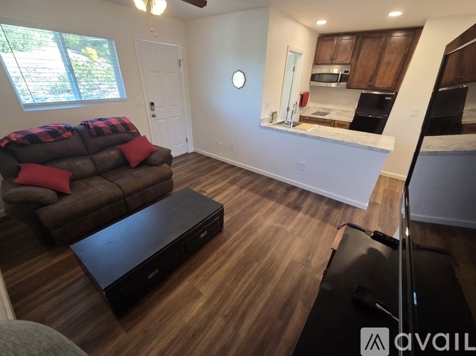 A living room with a brown couch and a black coffee table.
