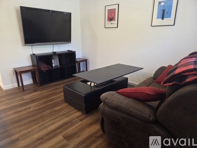 A living room with a couch, a coffee table, and a television.