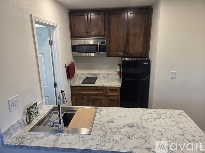 A kitchen with a marble countertop and wooden cabinets.