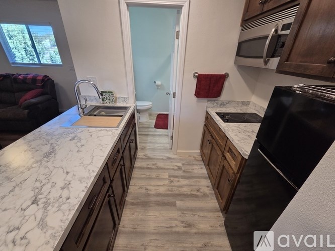 A kitchen with a marble countertop and wooden cabinets.