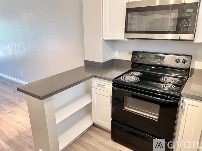 A black stove top oven with four burners and a microwave above it.