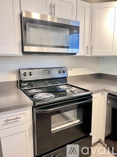 A modern kitchen with a stove and microwave above it.