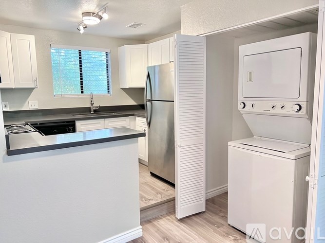 A kitchen with white appliances and cabinets.