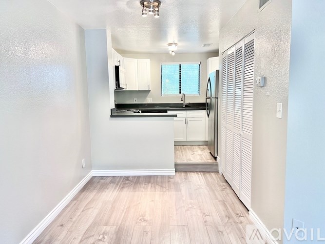 A kitchen with white cabinets and a wooden floor.