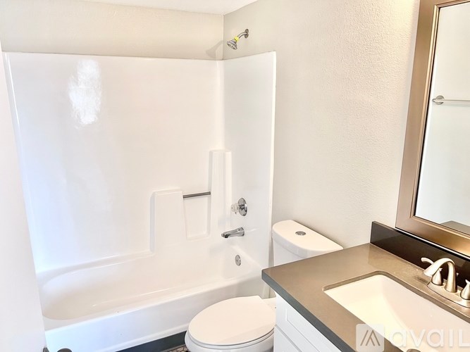 A white bathroom with a toilet, sink, and bathtub.