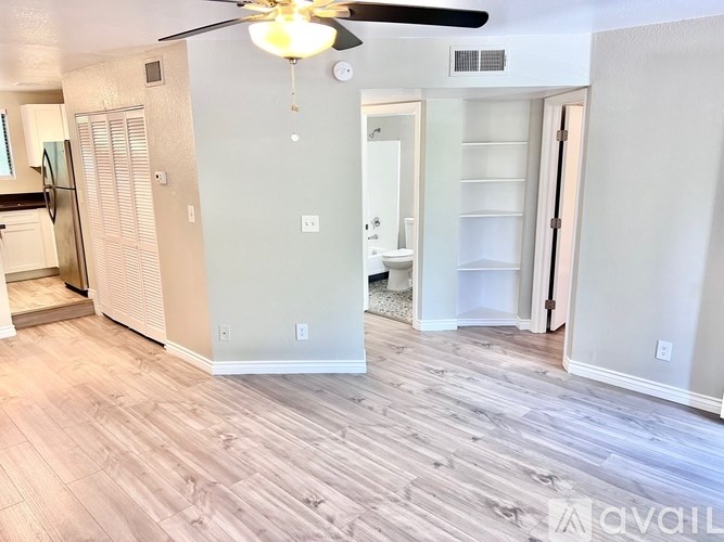 A living room with a ceiling fan and light fixture.