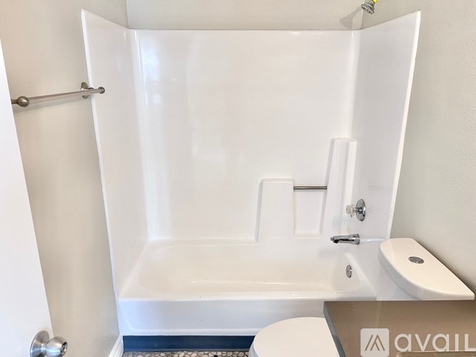 A white bathroom with a tub, toilet, and sink.