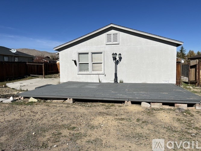 A small white house with a black lamp post in front.