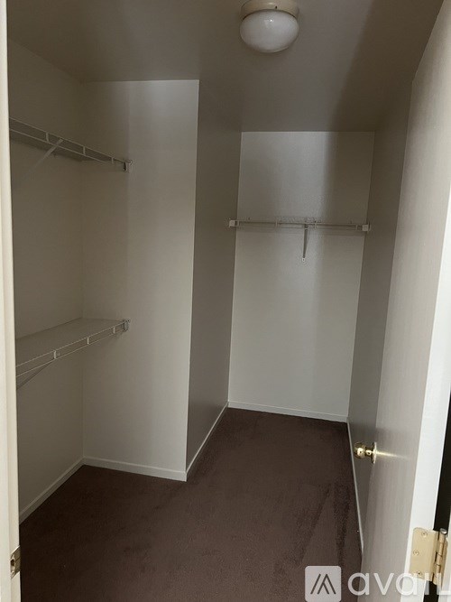 A small, empty room with a brown carpet and white walls.