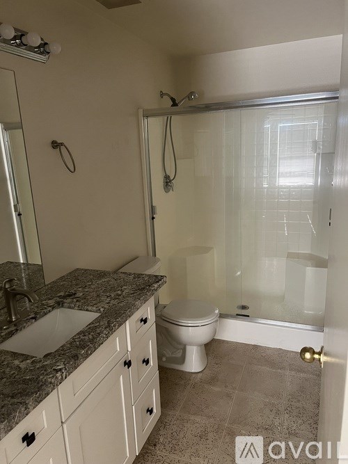 A bathroom with a sink, toilet, and shower.