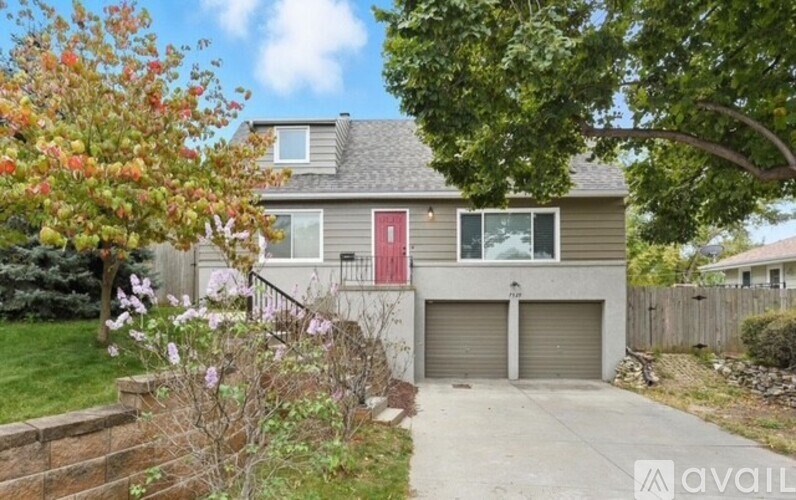 A house with a red door and a garage is for sale.