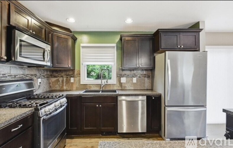 A kitchen with dark wood cabinets and stainless steel appliances.