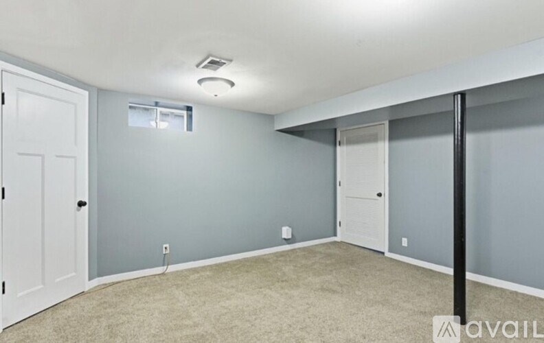 A room with a white door and a window with blinds.