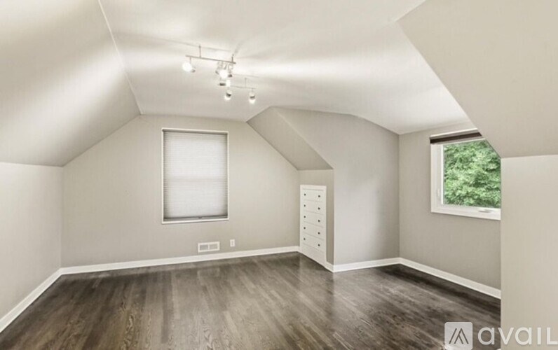 A room with a window and a wooden floor.