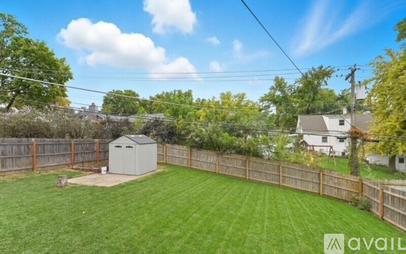 A backyard with a wooden fence and a shed.