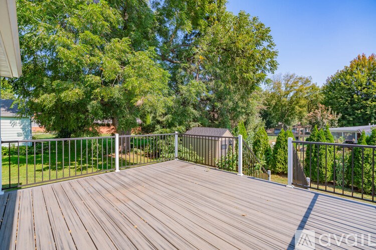 A deck with a railing and trees in the background.