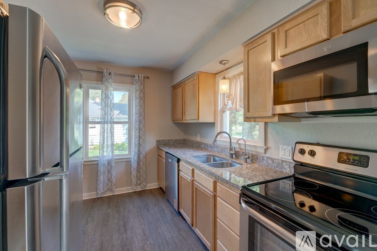 A kitchen with a stove, refrigerator, and sink.