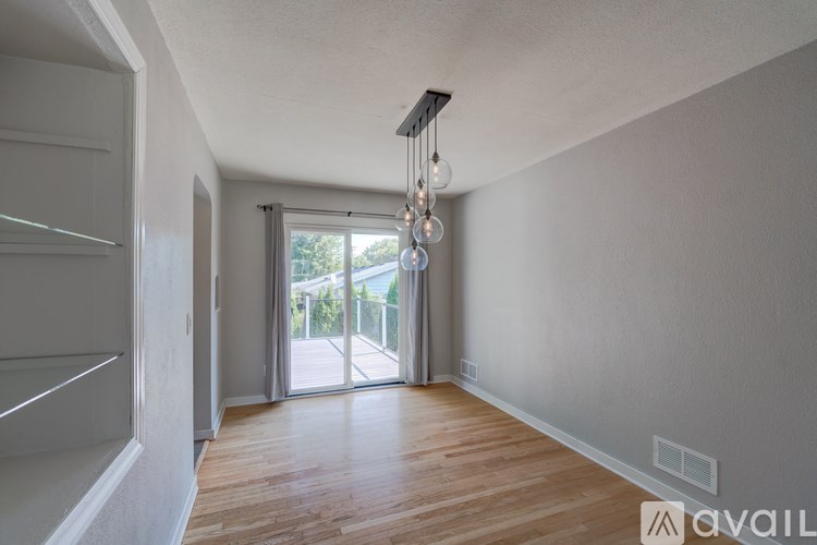 A modern interior space with wooden floors and a chandelier.