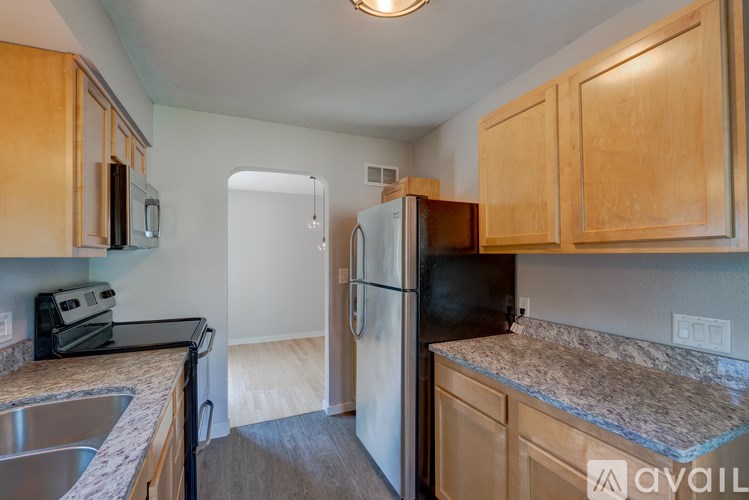 A kitchen with wooden cabinets and a granite counter top.