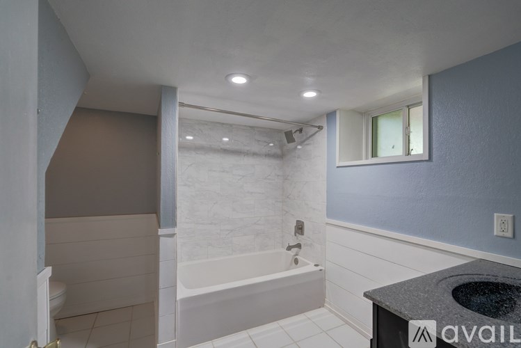 A bathroom with a tub, toilet, and sink.