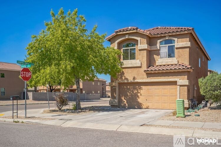 A house with a red roof and a tree in front of it.