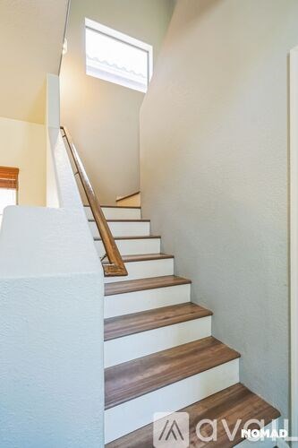A staircase with wooden steps and a white wall.