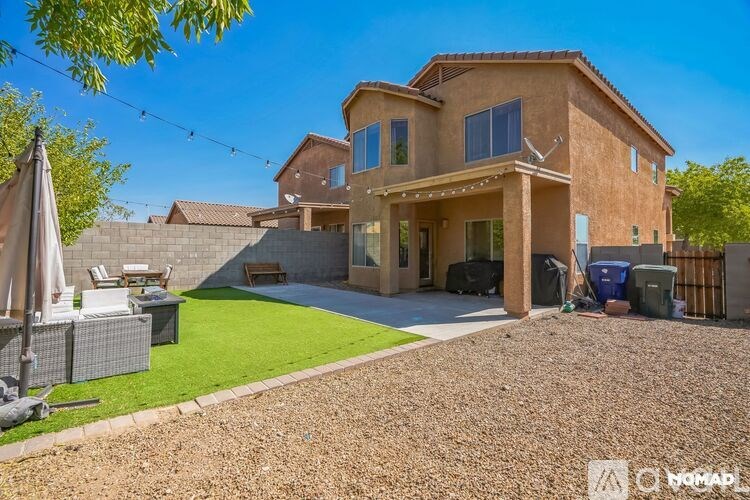 A house with a brown roof and a gravel driveway.
