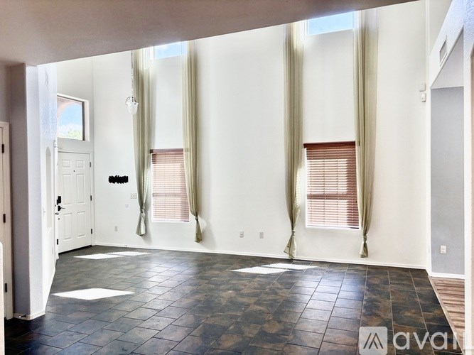 A room with a tiled floor and a window with blinds.