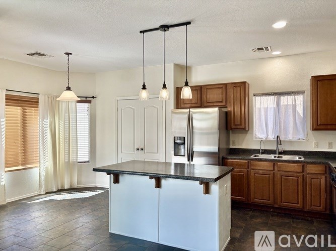 A kitchen with a white island and wooden cabinets.