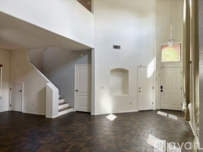 A large open room with a staircase and a chandelier.