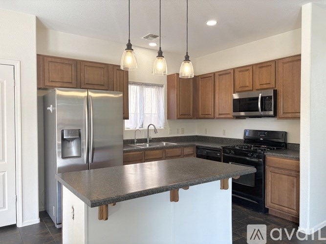 A kitchen with a refrigerator, microwave, and oven.