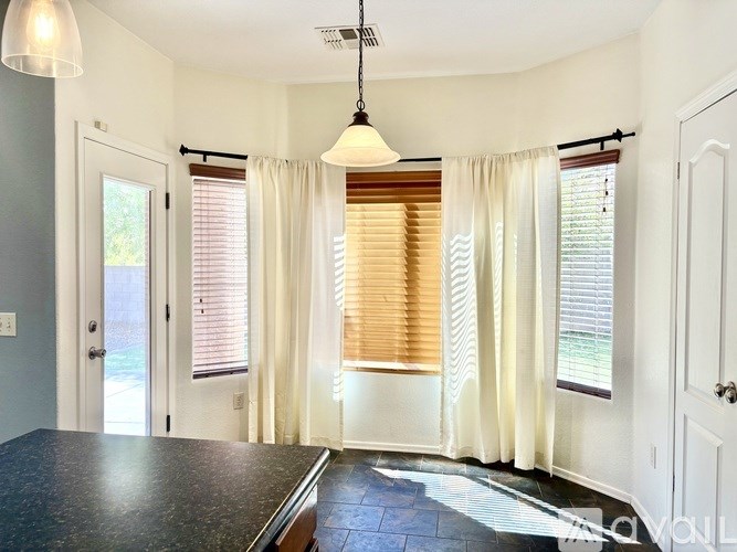 A room with a black counter top and a window with blinds.