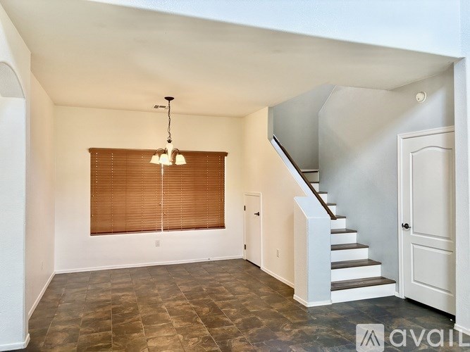 A spacious room with a staircase leading to another floor.