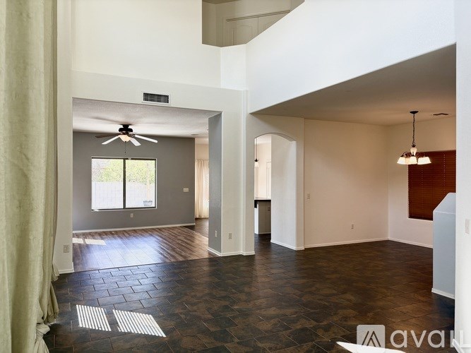 A spacious room with a ceiling fan and a large window.