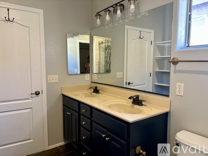 A bathroom with a sink, mirror, and light fixture.