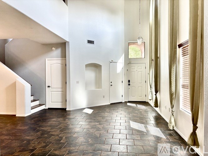 A hallway with a tiled floor and white walls.