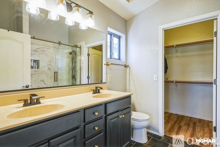 A bathroom with a marble counter top and a large mirror.