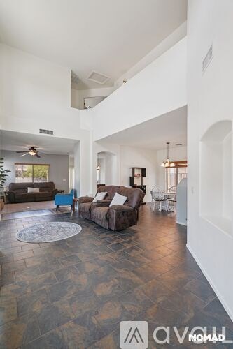 A living room with a couch, chairs, and a rug.