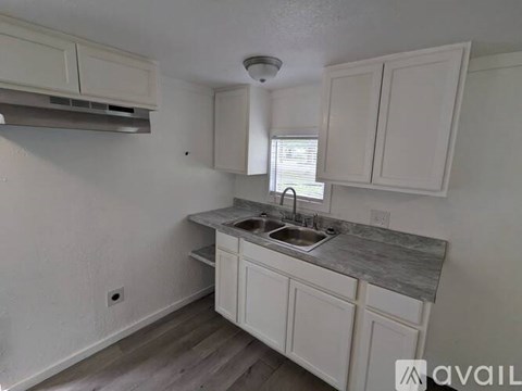 A kitchen with white cabinets and a marble countertop.