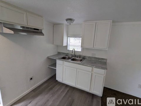 A kitchen with white cabinets and a marble countertop.