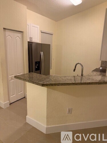 A kitchen with a granite countertop and a refrigerator.