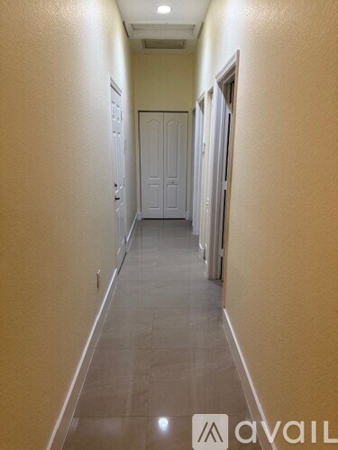 A long hallway with a door at the end.