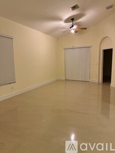 A room with a ceiling fan and a sliding door.