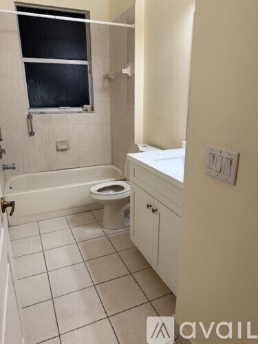 A bathroom with a toilet, sink, and bathtub.