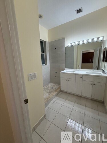 A bathroom with a white cabinet and a white sink.