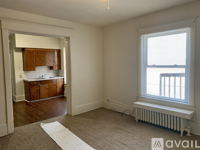A room with a window and a radiator is available for rent.